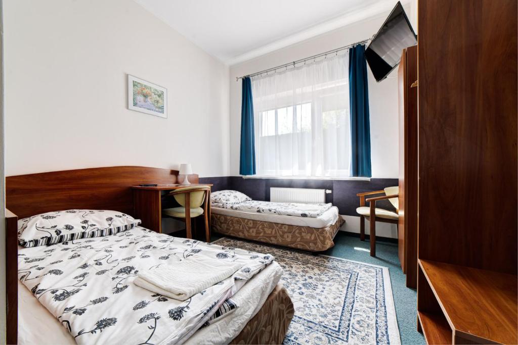 sypialnia z dwoma łóżkami i oknem w obiekcie Pokoje Hotelowe Norbit w mieście Grodzisk Mazowiecki