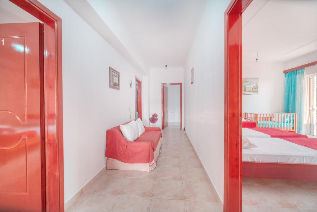 a living room with a red couch and a mirror at Mirror Beach Ksamil - Vila Zervo in Sarandë
