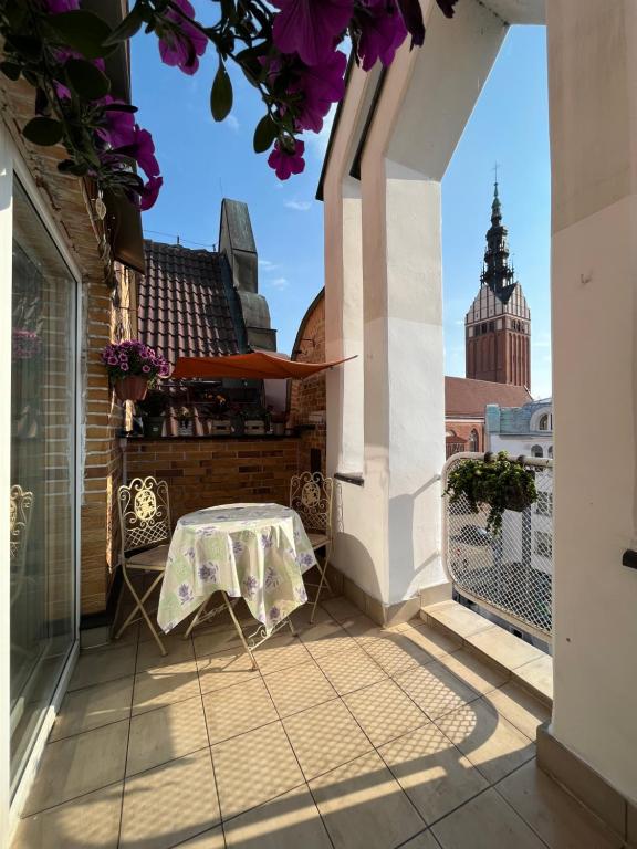 a table on a balcony with a view of the city at Gael Stary Rynek 1 in Elblag