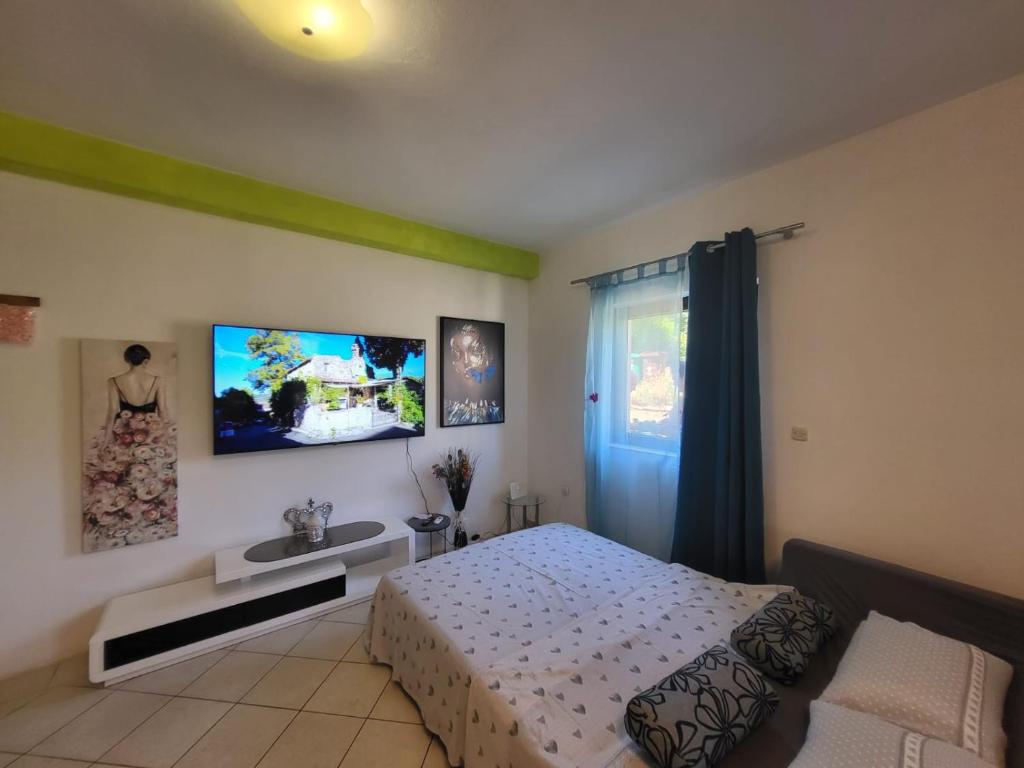 a bedroom with a bed and a tv on the wall at Apartments Pula with private parking Self Check In in Pula