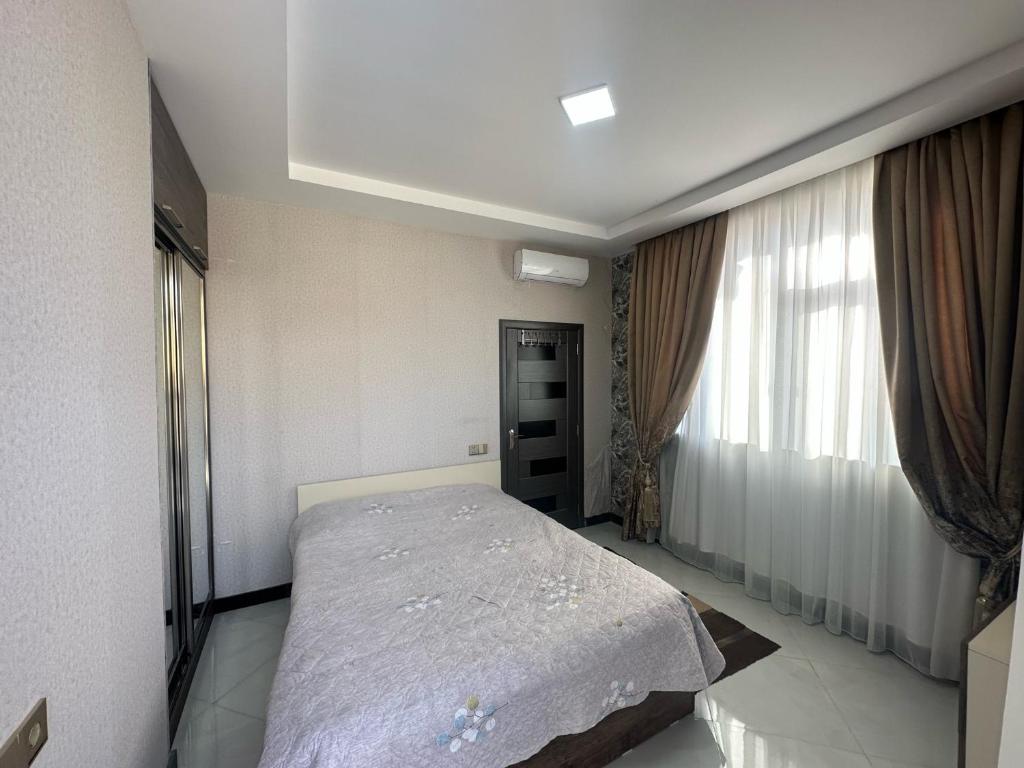 1 dormitorio con cama y ventana en Villa Novxani, en Baku