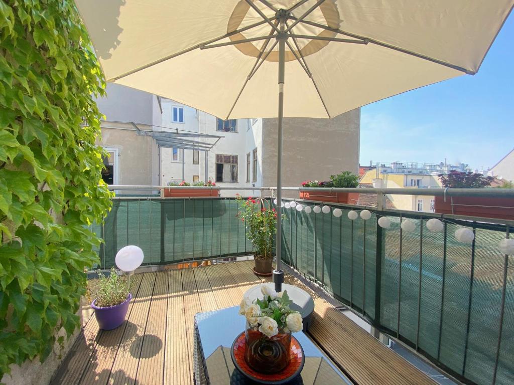 uma mesa com um guarda-chuva numa varanda em Magic Vienna Balcony Apartment em Viena
