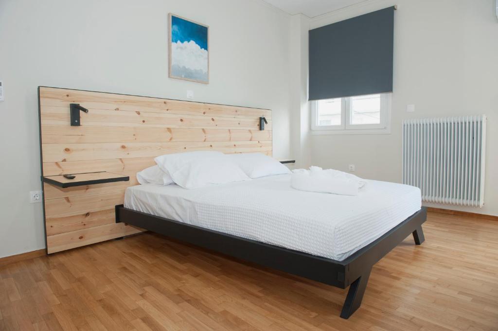 - une chambre avec un grand lit et une tête de lit en bois dans l'établissement Olympia luxury apartment in Marousi, à Athènes