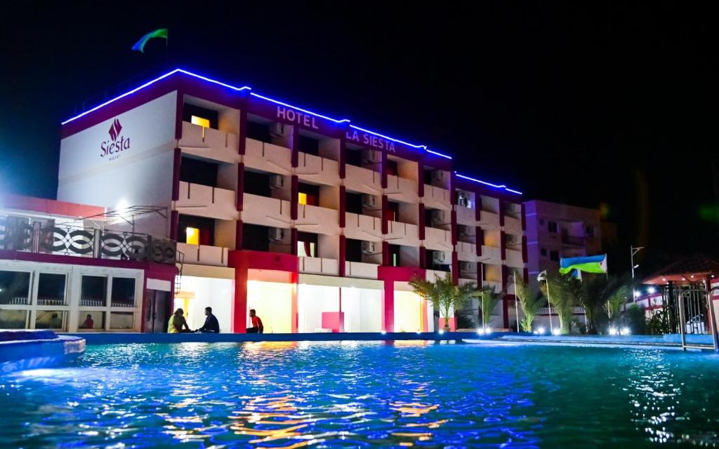 un hotel por la noche con una piscina delante en SIESTA HOTEL, en Yibuti