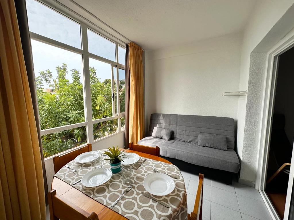 un salon avec une table et une grande fenêtre dans l'établissement Apartamentos Sol y Luna 3000, à Peñíscola