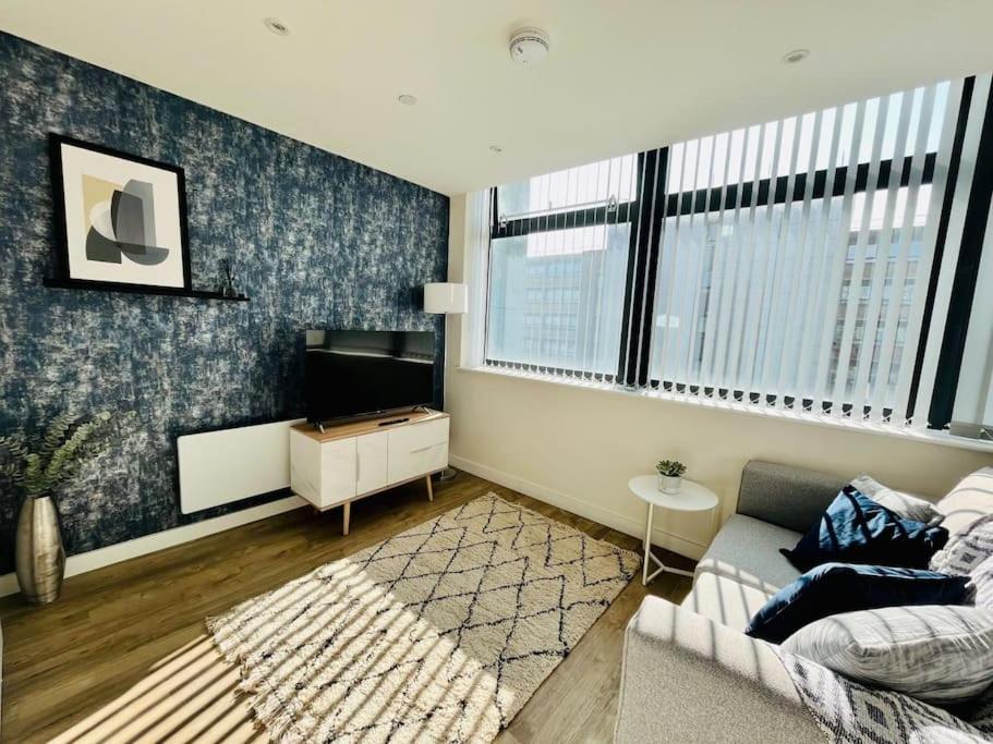 ein Wohnzimmer mit einem Sofa und einem TV in der Unterkunft Stunning one bedroom apartment in Old Trafford in Manchester