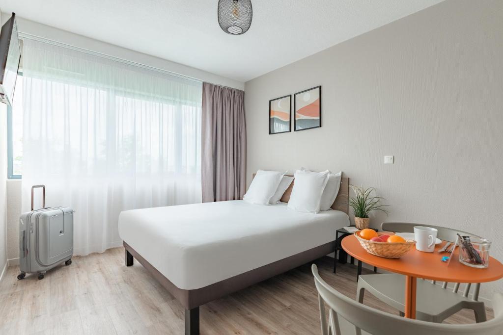 um quarto de hotel com uma cama e uma mesa em Appart'City Classic Bordeaux Centre em Bordéus