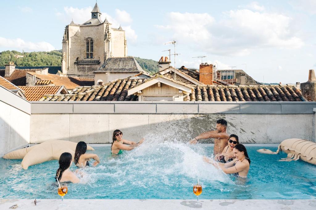 un groupe de personnes dans une piscine dans l'établissement Appart'hôtel Les Fleurines By Urban Style, à Villefranche-de-Rouergue