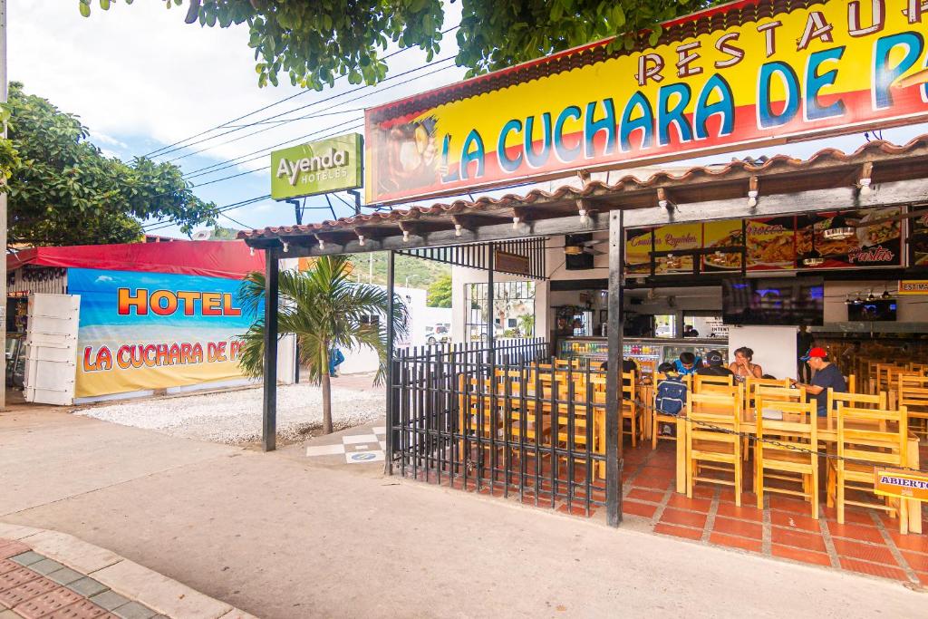 een restaurant met houten tafels en stoelen ervoor bij Hotel Cuchara de Palo Ayenda in Santa Marta