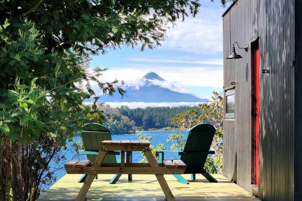 フルティジャールにあるExclusiva Cabin en tranquilo campo a orillas del lago con vista a volcanes - hot tub privadoの山の景色を望むデッキ(テーブル、椅子付)