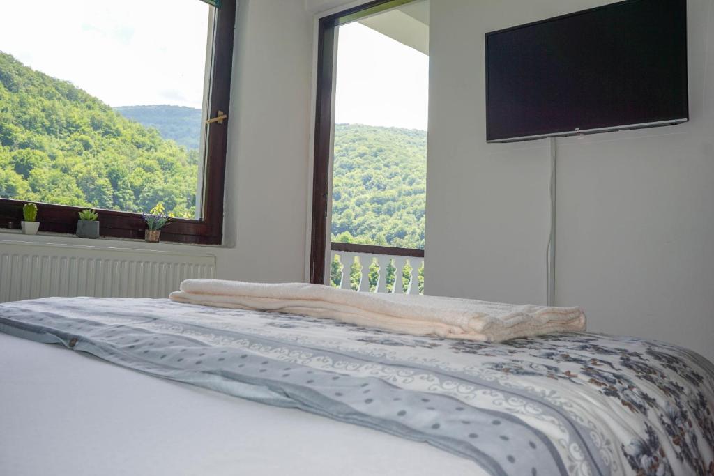 a bed in a room with a large window at VIP Rooms Foča, Accommodation Foca, Foca Rooms in Foča