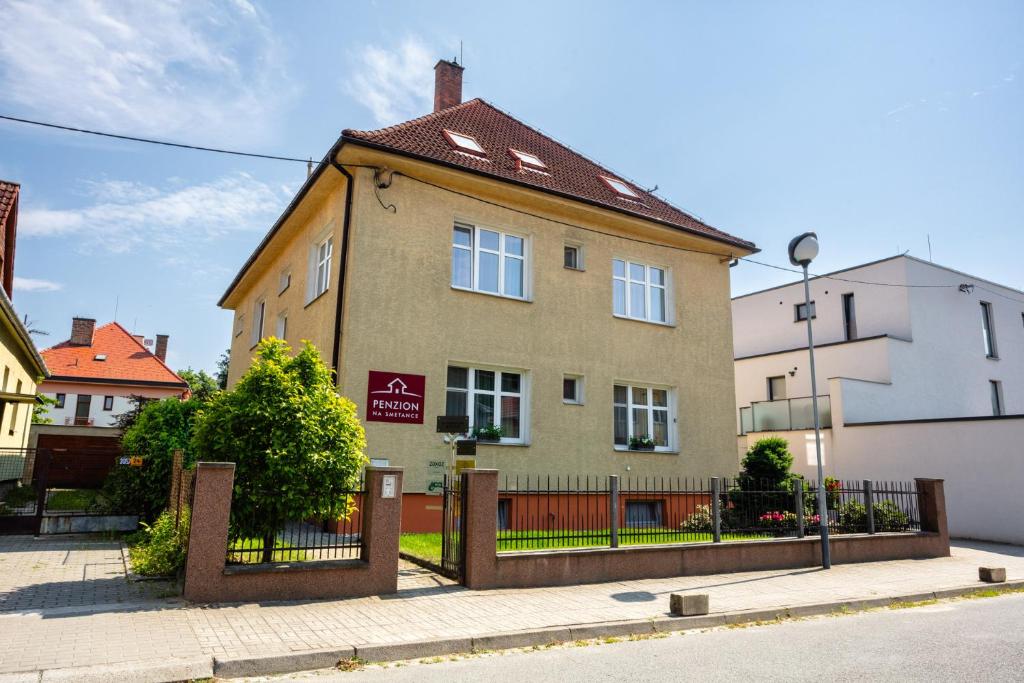uma casa com uma cerca em frente em Penzion na Smetance em Zlín