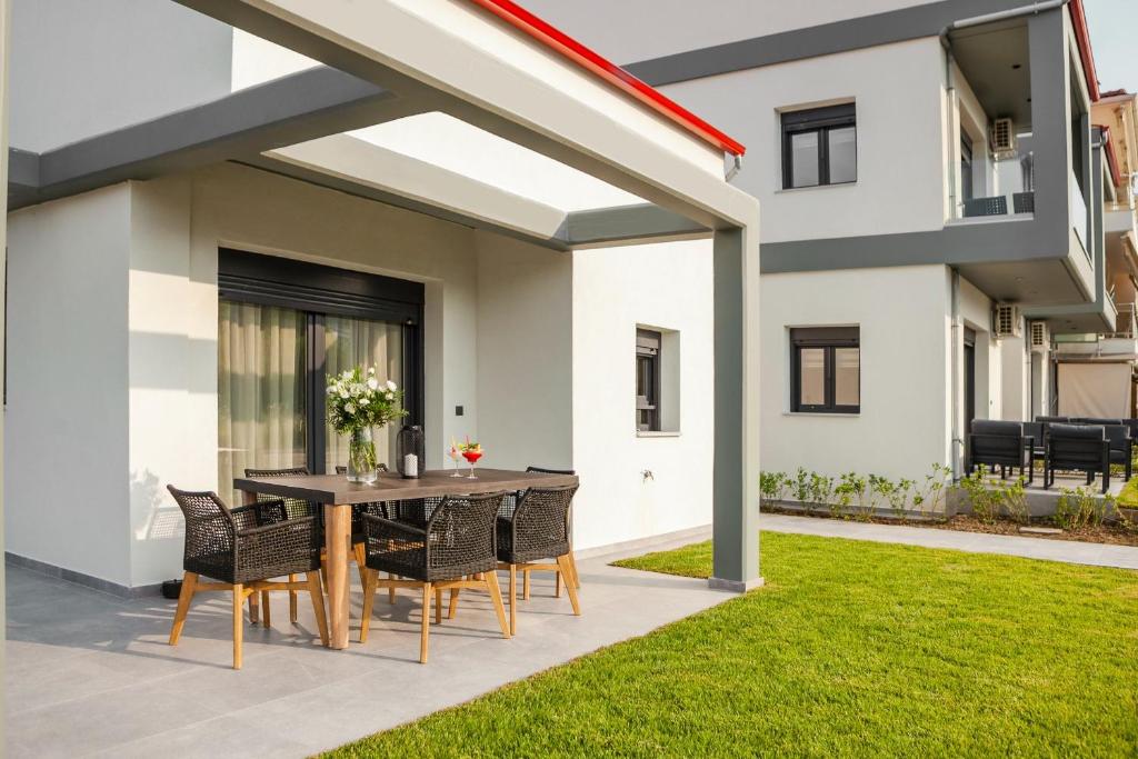 a patio with a table and chairs in a yard at Villa Irene in Polychrono