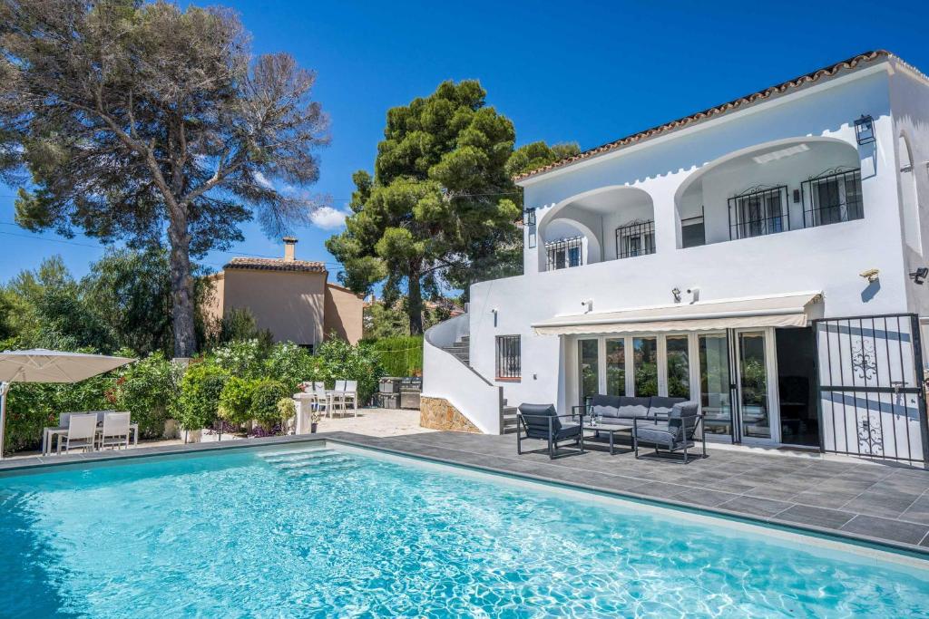 une villa avec une piscine en face d'une maison dans l'établissement Villa Luxe, à Calp