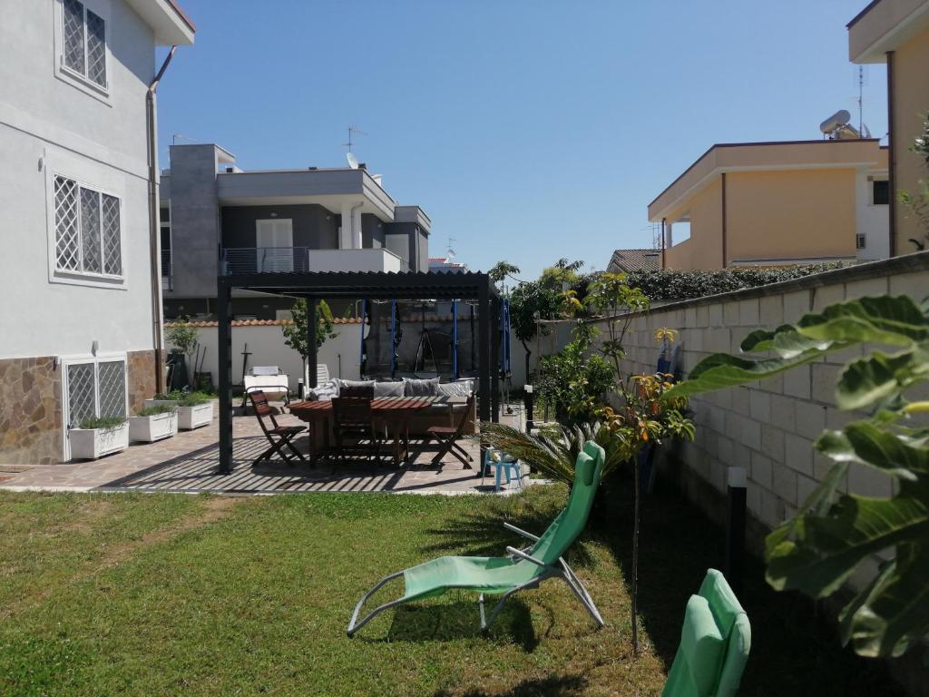 a garden with a table and chairs in a house at Villa Vita - Monolocale con giardino in Acilia