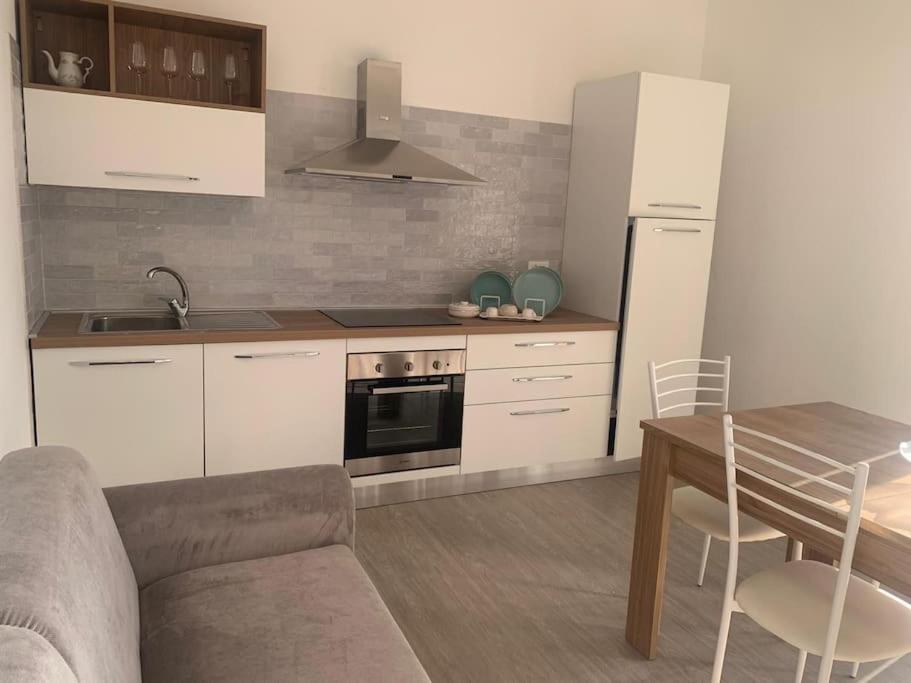een keuken met witte kasten en een tafel en een bank bij Appartamentino3 Collina Costa Dei Trabocchi in Villalfonsina