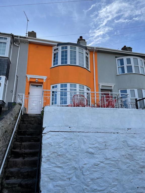 an orange and white house with a fence in front of it at Number Eleven, Brixham in Brixham