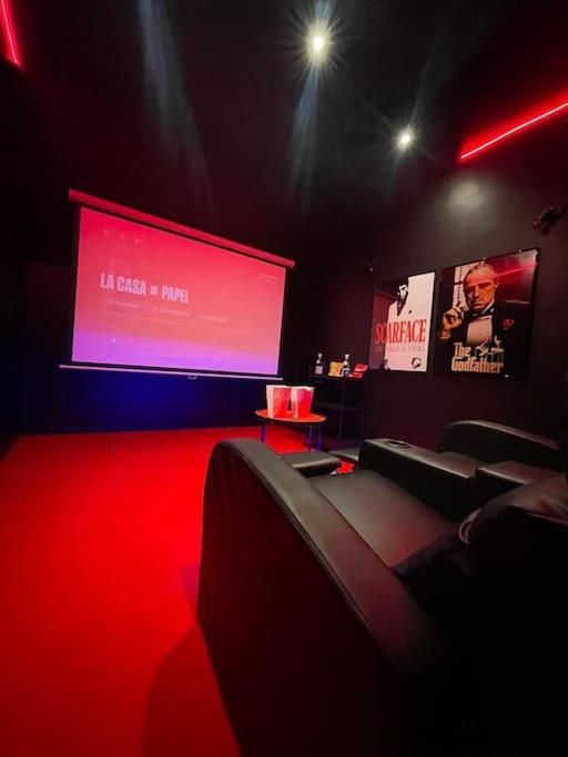 a room with a large screen with chairs and a projector at La Suite Casa Dé lové 2.0 jacuzzi & cinema privé in Melun