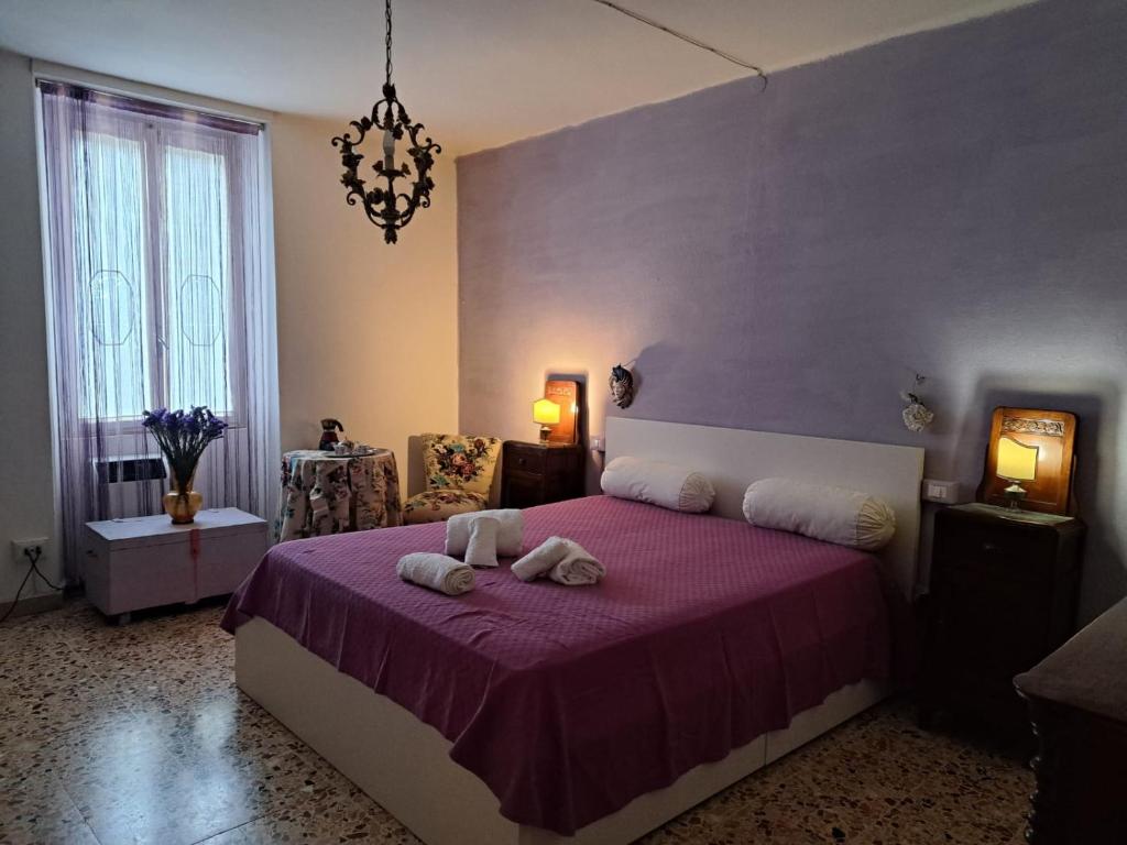 una camera da letto con un letto viola e due asciugamani di Casa Luci d'Alba a Monzambano