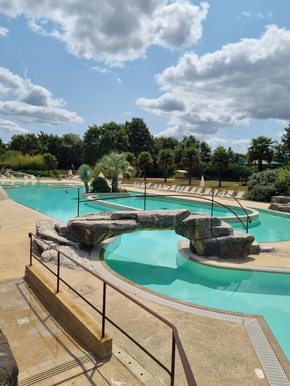 einen Pool in einem Park mit blauem Wasser in der Unterkunft Camping de l Orangerie de Lanniron Mobilhome Esprit Zen R26 in Quimper