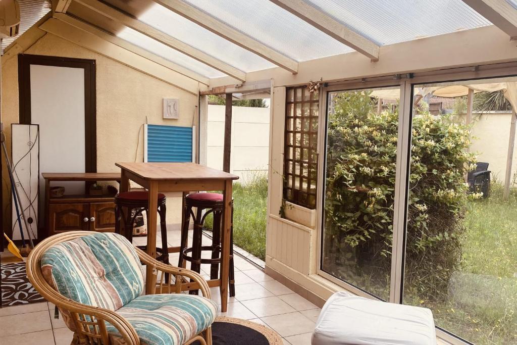 une véranda avec une table et des chaises dans l'établissement Spacious 100m house in La Teste-de-Buch, à La Teste-de-Buch