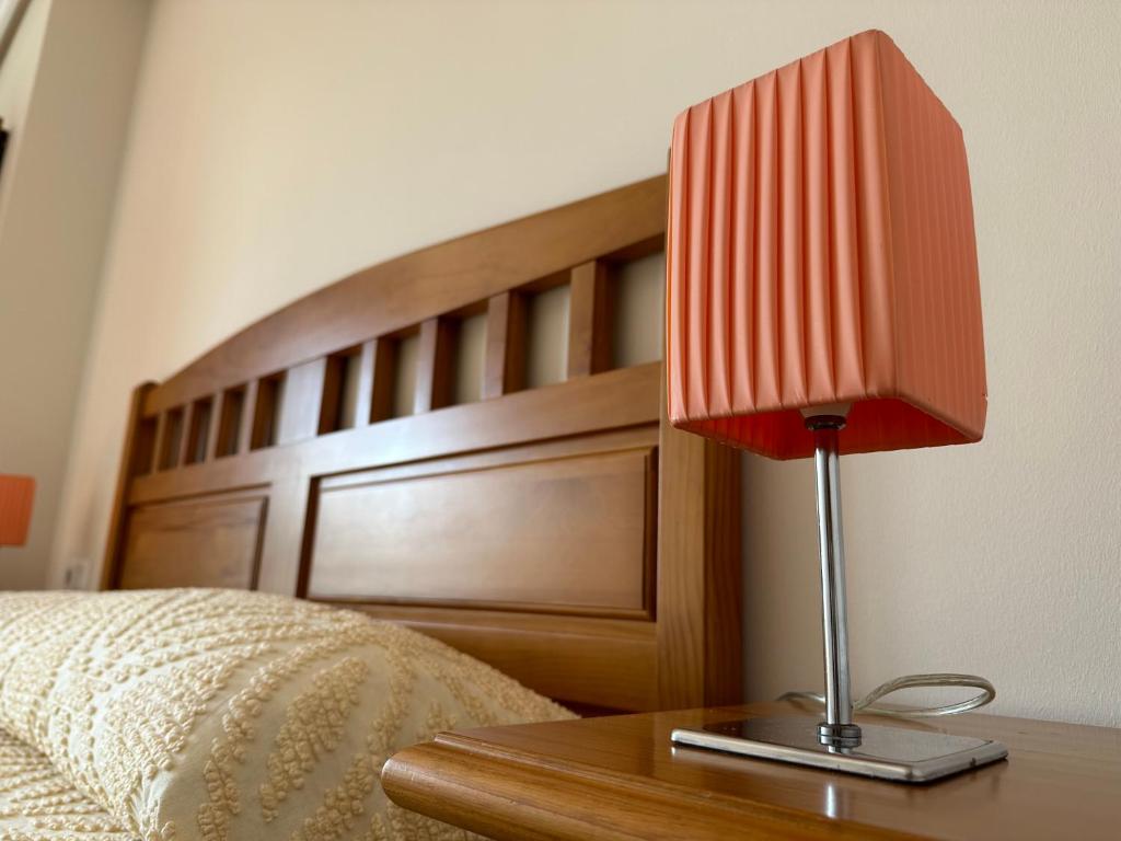 czerwone światło na stole obok łóżka w obiekcie Apartamento Salgueirón w mieście Cangas de Morrazo