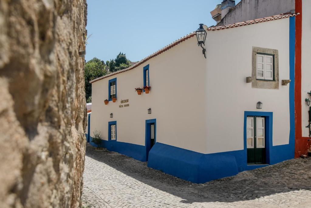 una fila de edificios blancos y azules en una calle en Óbidos Pátio House en Óbidos