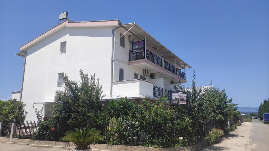 a white building with trees in front of it at Maki Apartmani in Ulcinj