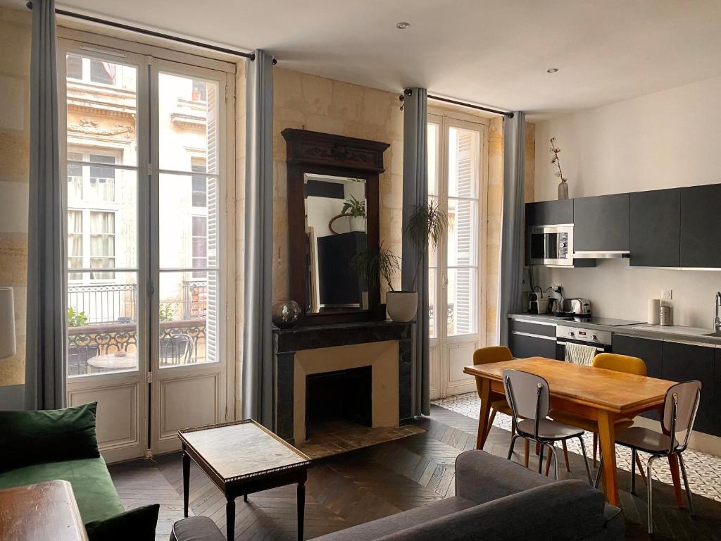 a living room with a table and a fireplace at Appartement balcon centre historique in Bordeaux