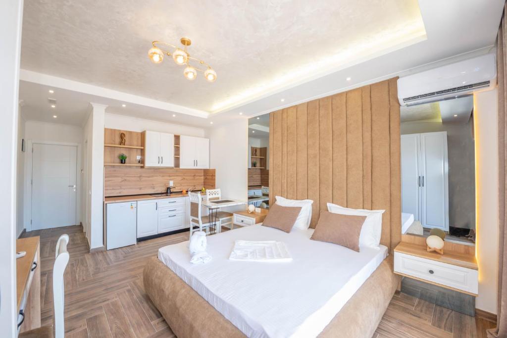 een slaapkamer met een groot wit bed en een keuken bij Twins Apartment in Ulcinj