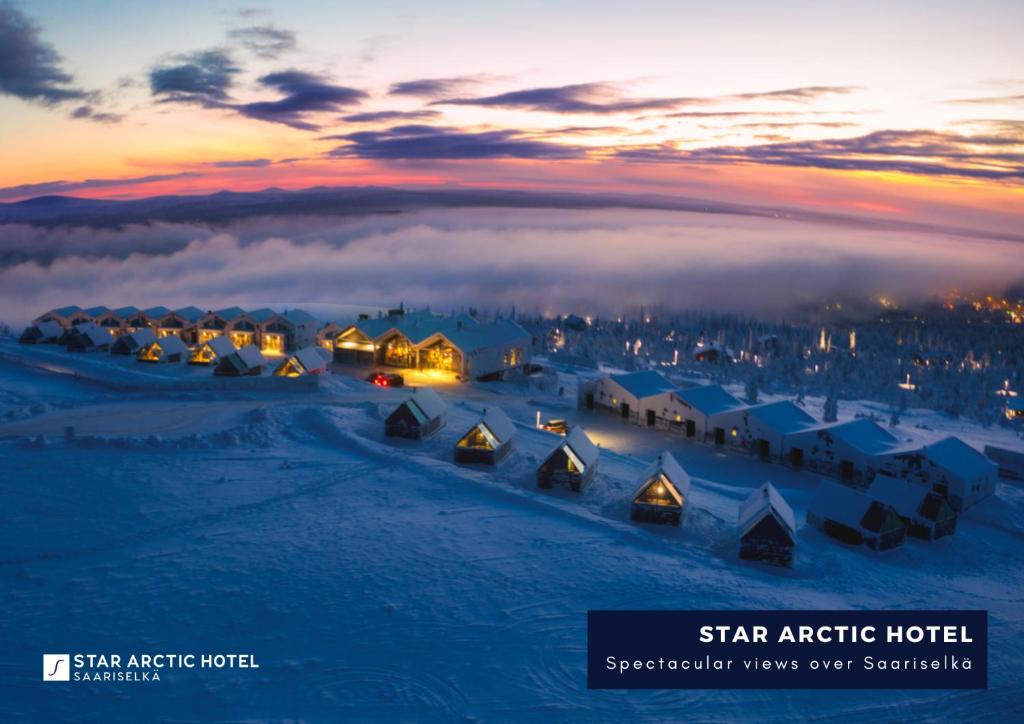 Blick auf das arktische Sternehotel im Schnee bei Sonnenuntergang in der Unterkunft Star Arctic Hotel in Saariselkä