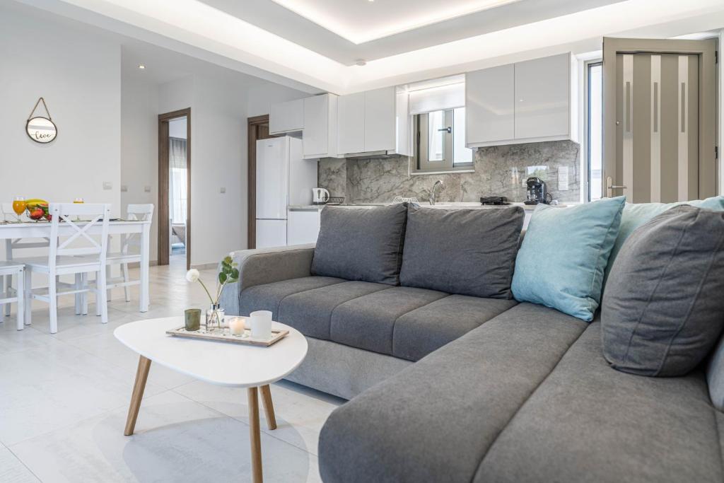 a living room with a gray couch and a table at Diorisa House in Lartos