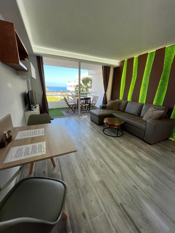 a living room with a couch and a table at Hideaway Tenerife Holiday Apartment Las Américas in Playa Fañabe