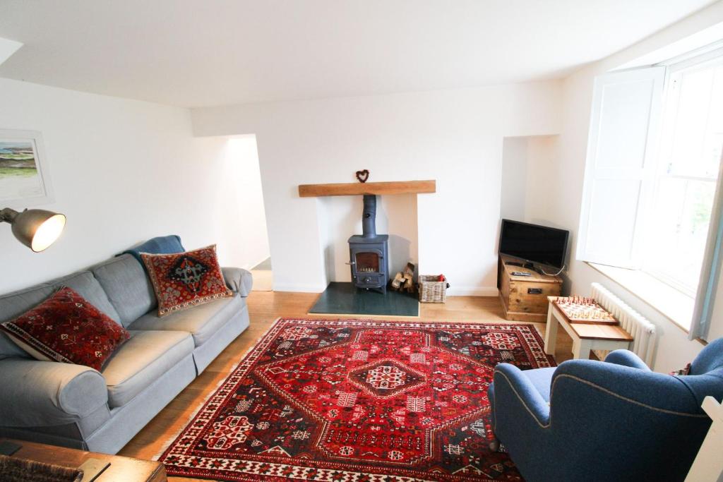 a living room with a couch and a fireplace at Sedbergh Cottage, Sedbergh in Sedbergh