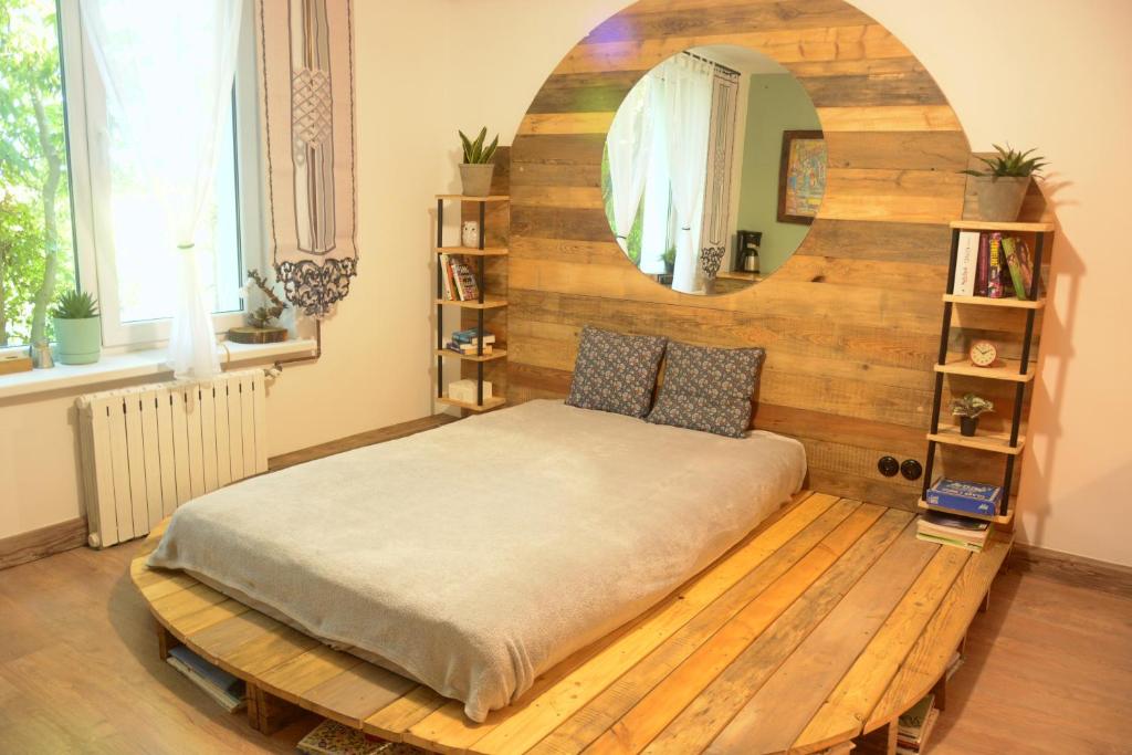 a bedroom with a bed with a large mirror at Magic Wood Studio Apartament Koniewo in Lidzbark Warmiński