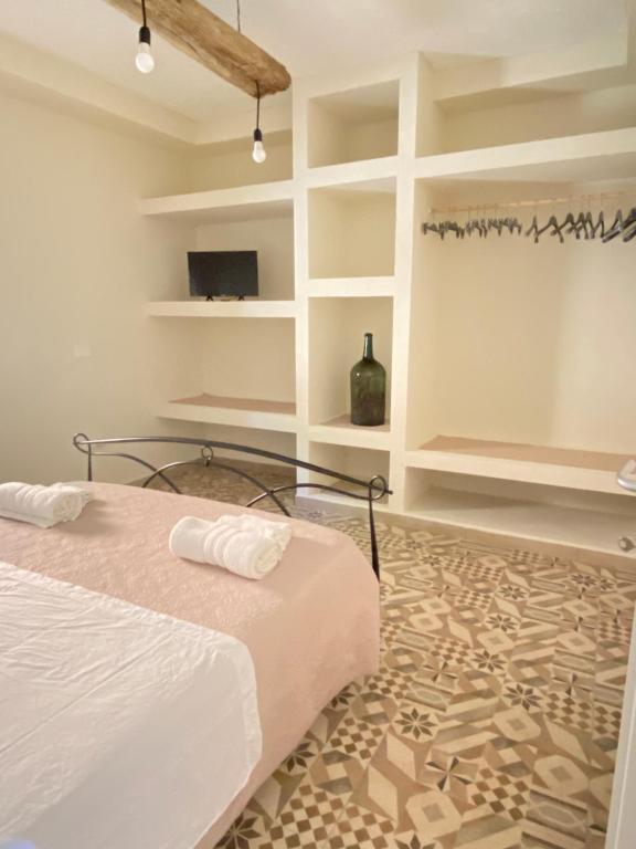 um quarto com uma cama, uma televisão e prateleiras em DONNA PETRONILLA SOUTHERN HOUSE em Pianopoli