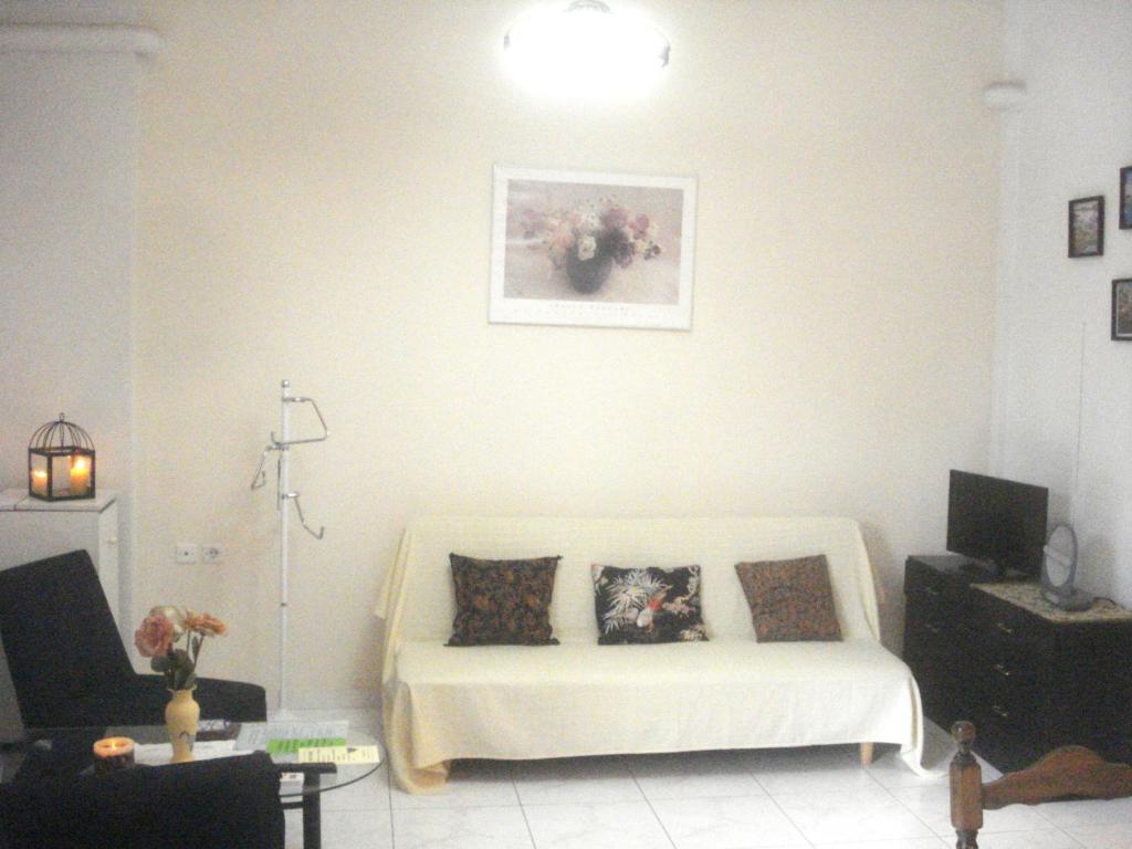 a living room with a white couch with two pillows at SOFIES CHOICE Suite in Chalkida