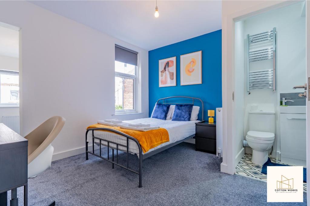 Dormitorio azul con cama y aseo en Monthly Offers, 10 Guests, Business, WIFI, en Derby