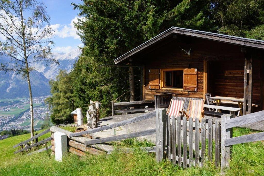 eine Holzhütte mit einem Zaun davor in der Unterkunft Walters Hütte in Tulfes