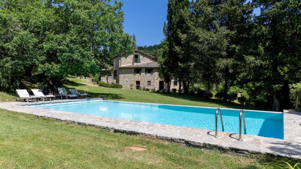 een zwembad in de tuin van een huis bij MULINO NEL CHIANTI 10, Emma Villas in Gaiole in Chianti