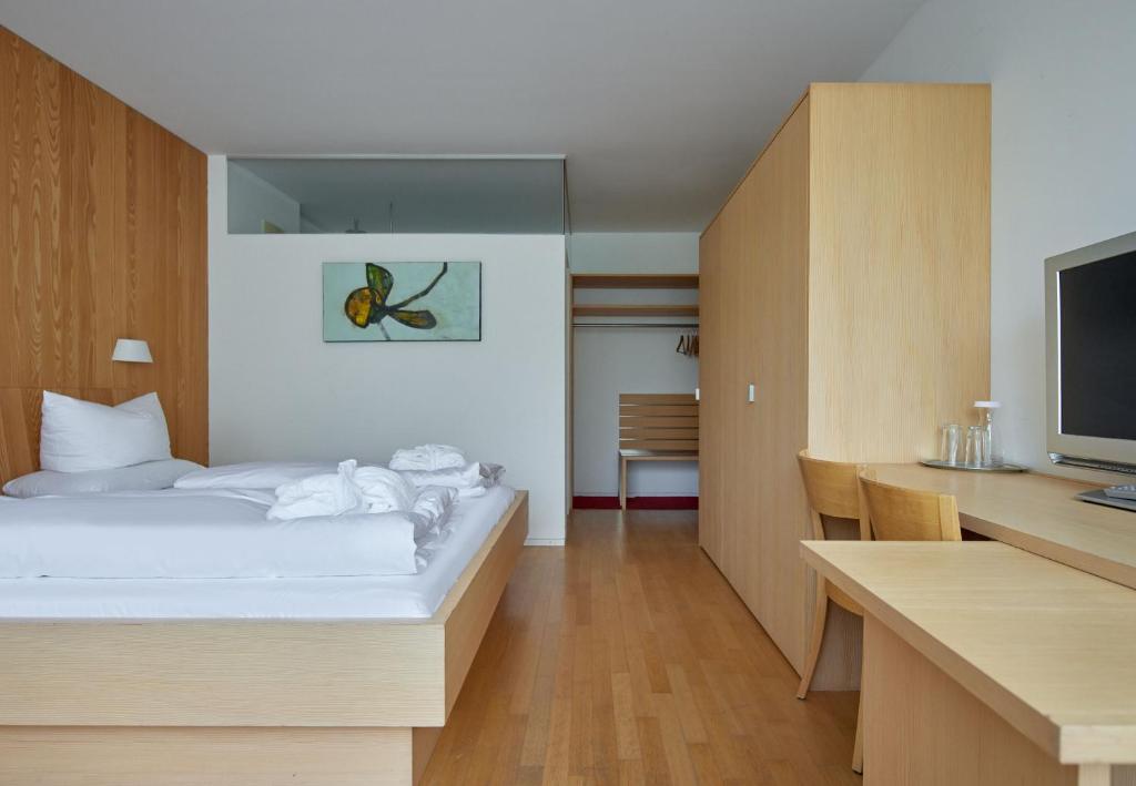 a bedroom with a bed and a desk and a television at Bonawinkel NEU in Gaschurn