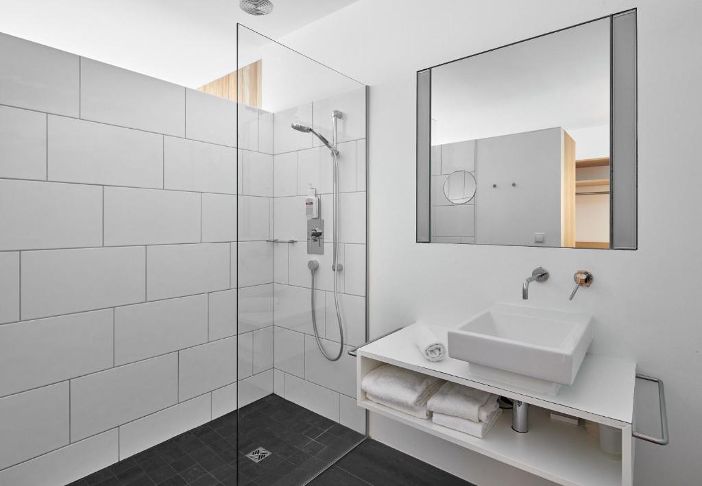 a white bathroom with a sink and a shower at Bonawinkel NEU in Gaschurn