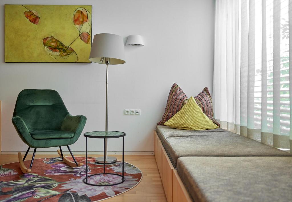a living room with a couch and a green chair at Bonawinkel NEU in Gaschurn