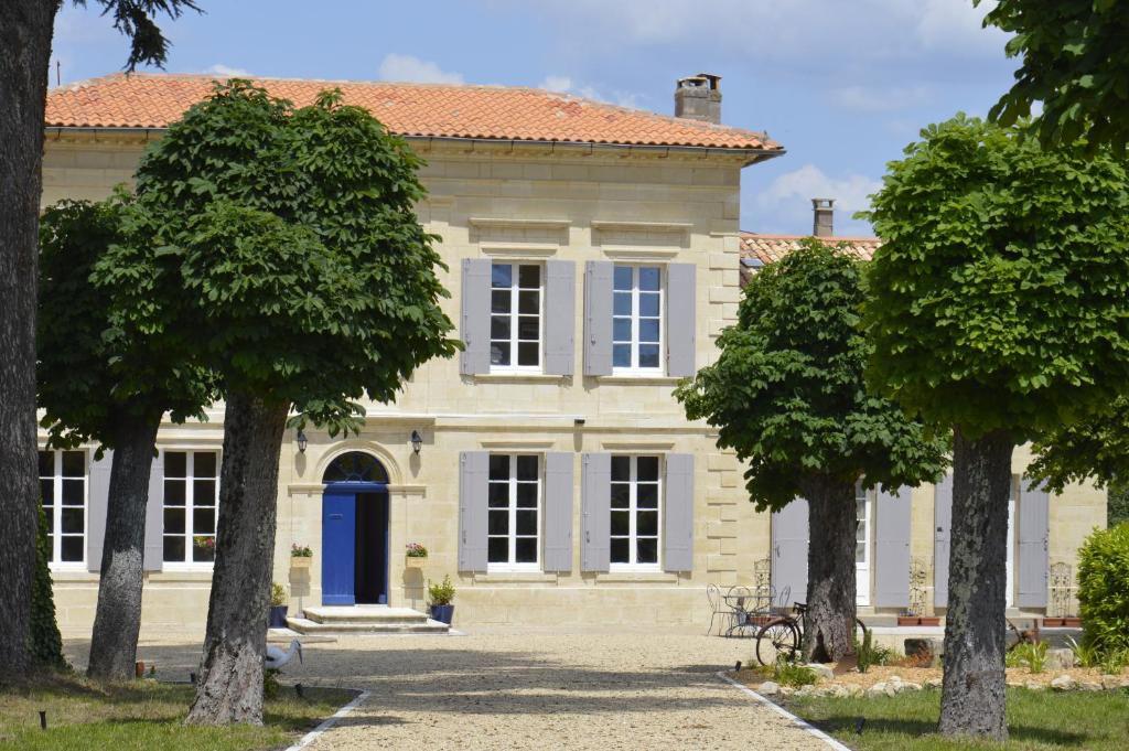 ein großes Haus mit Bäumen davor in der Unterkunft Château Nardon Crimon in Saint-Christophe-des-Bardes