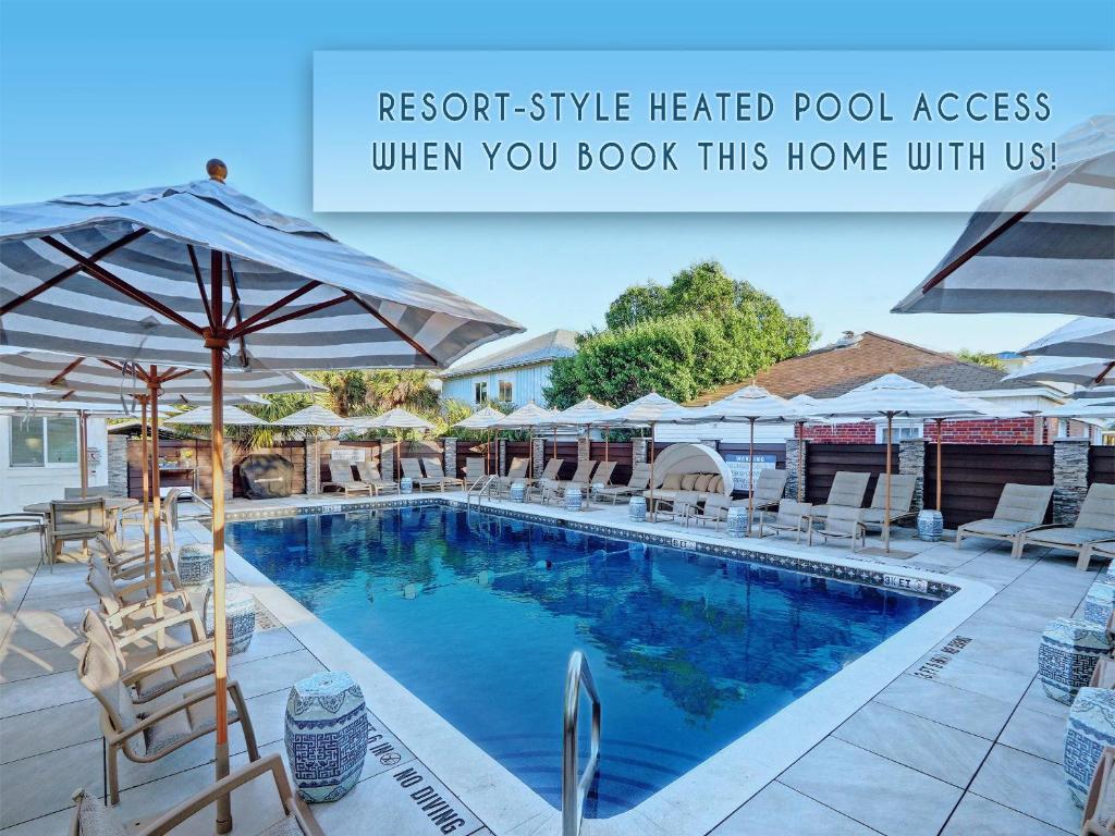 a swimming pool with chairs and umbrellas at Bird Baldwin Suite Liberty in Savannah