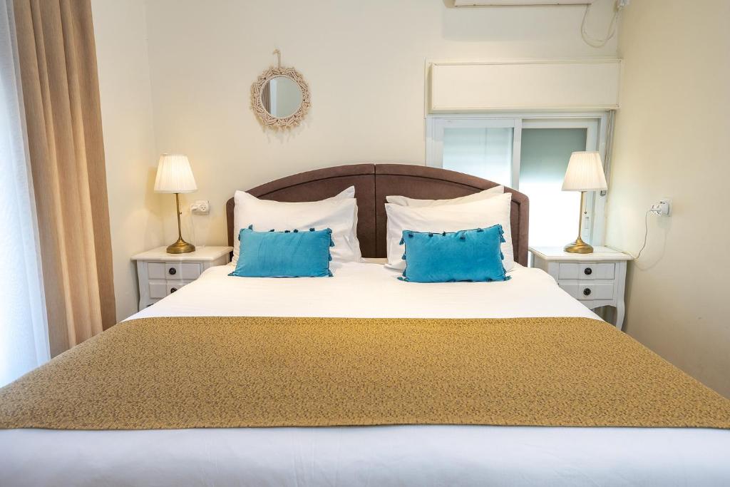 a bedroom with a large bed with blue pillows at Mike's House Jerusalem in Jerusalem