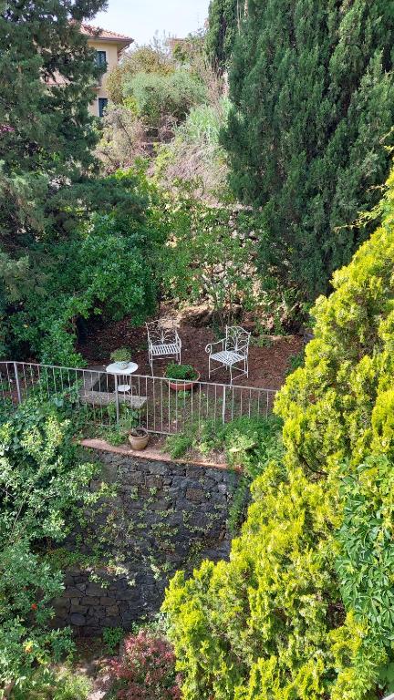 duas cadeiras e uma mesa num jardim em Casa Delle Coccole em Trecastagni