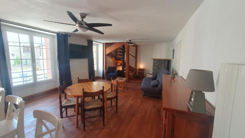a dining room and living room with a table and chairs at Charmante maison de village in Condat-sur-Vézère