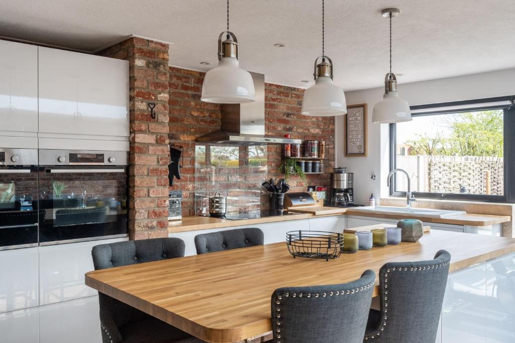 a kitchen with a wooden table and chairs at At Last in West Beckham