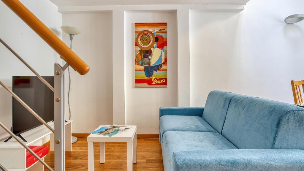 een blauwe bank in een woonkamer met een klok aan de muur bij Italianway - Paisiello 4 B in Milaan